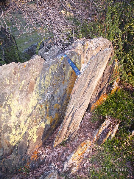 _1316554.JPG - My rock hammers is spanning the space between a foliated face of rock.