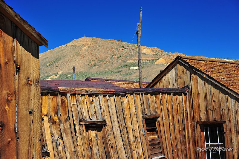 RJH_4265.JPG - Run down houses with the dacite plugs within the Bodie hills that brought many riches to the area.