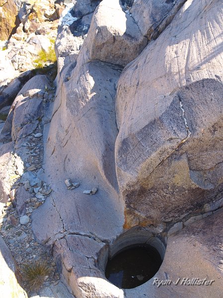 20090816_20_Lakes_Basin_0356.JPG - Although the lighting was bad, this was perhaps one of the most unique features I came across: a pothole amongst the glacially carved rocks located near the top of the hill.  Potholes form when pebbles get trapped within a stream's eddy... the swirling action of the eddy spins the pebble in circles slowly grinding the rock away and leaving these neat features.