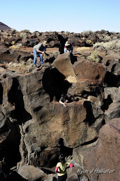 _DSC0057.JPG - The other great spot to experience at Fossil Falls is what I like to call the "Manhole".  It's  a pothole thats drilled-its way down nearly 10 feet or so.  One starts at eh bottom and has to wedge themself up the 24 inch wide hole to the top.  Here, Random does his best to emerge.