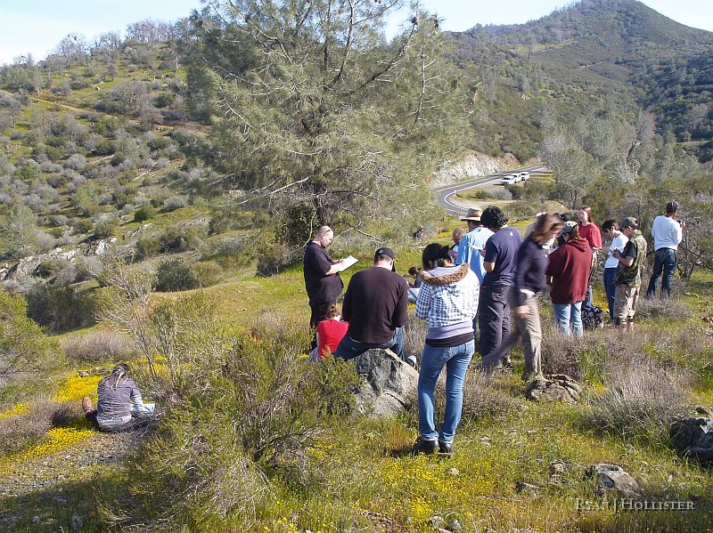 _3147147.JPG - So why bring a group of students here?  Well....  They're sitting on a rare complex of nearly unaltered peridotite, with a bunch of highly altered serpentine visible in the background along the road cut.  Short story:  This WAS a subduction zone where the Foothills Terraine finally collided with the Calaveras Complex some 160 mya. The rock we were standing on was some of the deep mantle rock that caught up in the mix..