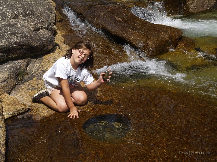 _8054548.JPG - Jillian shows us one of the culprit grinding stones that played a role in the formation of the pothole.